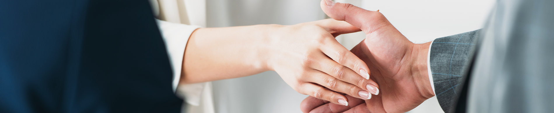 A photo of two people shaking hands. Only the hands are visible.