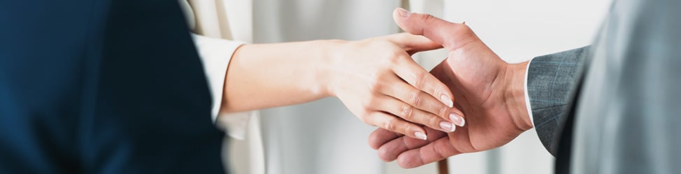 A photo of two people shaking hands. Only the hands are visible.