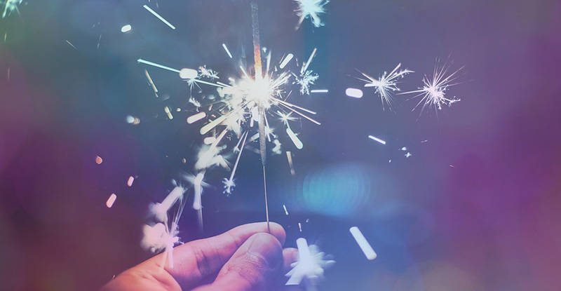 A photo of a person holding a sparkler creating a whimsical look.