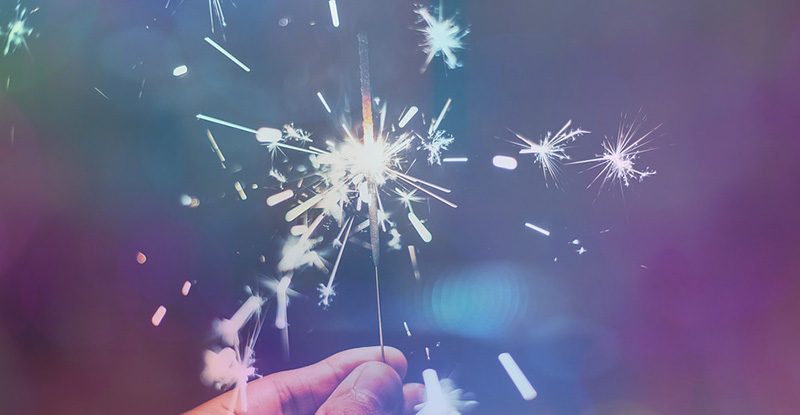 A photo of a person holding a sparkler creating a whimsical look.