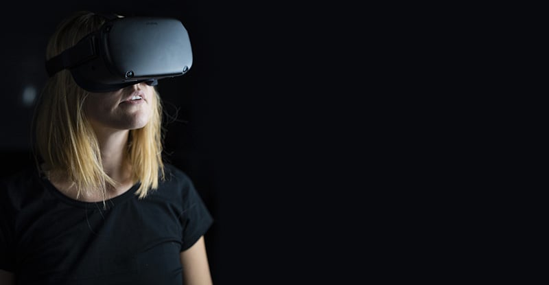 A photo of a woman wearing a meta headset.