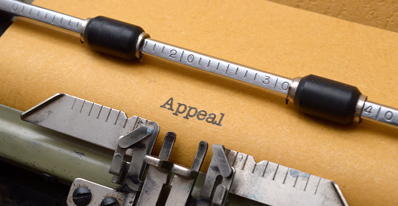 A photo of a typewriter that reads "Appeal" on a brownish-yellow sheet of paper.