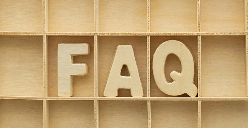 A photo of a wooden shelf with the letters 'FAQ,' also made from wood, fitted into the shelves.