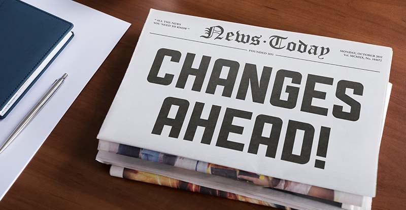 A photo of a newspaper placed on top of a table that reads, "News today: Changes ahead".