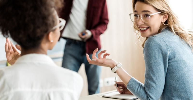 A photo of students discussing and laughing at something.