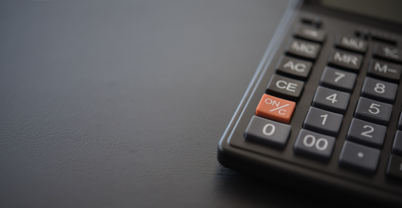 A photo of a calculator visible partially on a grey desk.